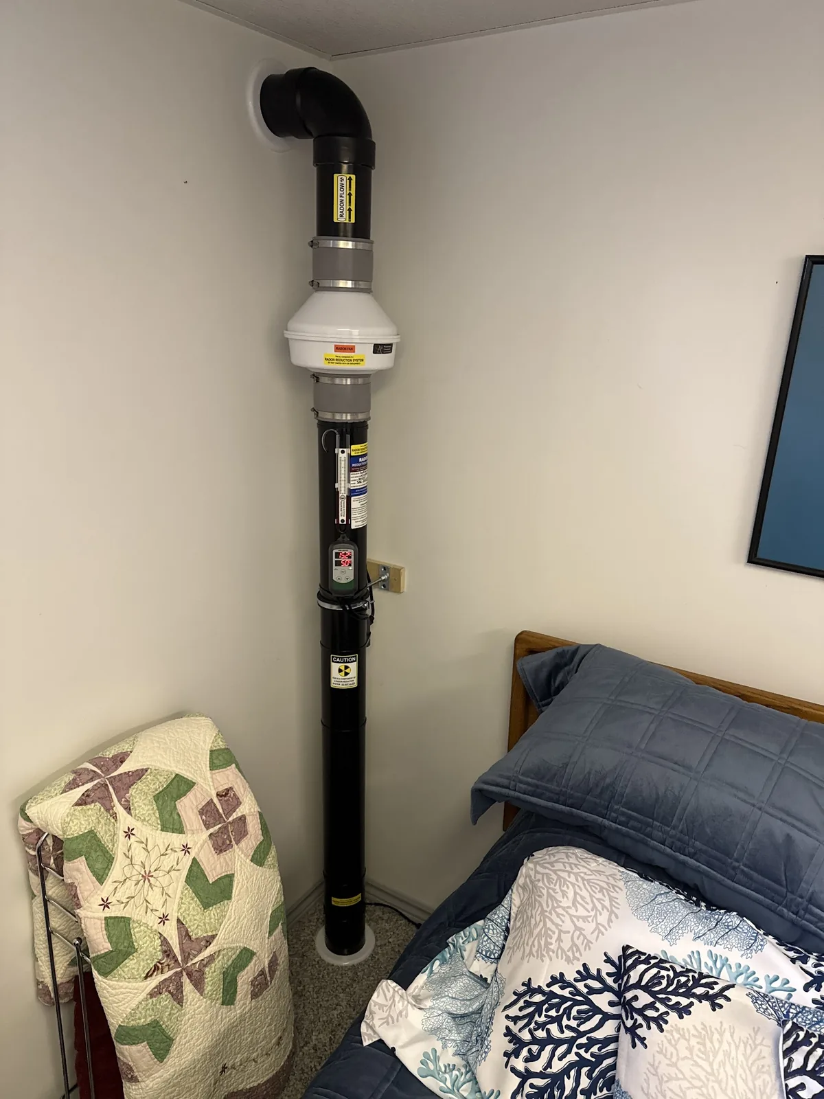A Sask Air technician checking a radon mitigation fan